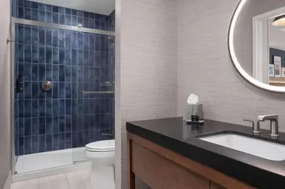 a bathroom with a sink and a toilet and a mirror at The Well House Hamilton, Tapestry Collection By Hilton in Hamilton