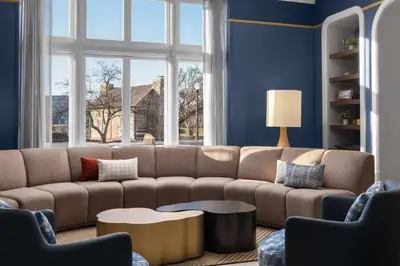 a living room with a couch and a large window at The Well House Hamilton, Tapestry Collection By Hilton in Hamilton
