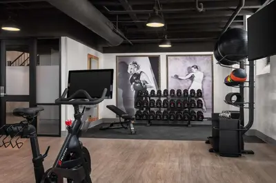 a gym with exercise equipment and paintings on the walls at The Well House Hamilton, Tapestry Collection By Hilton in Hamilton