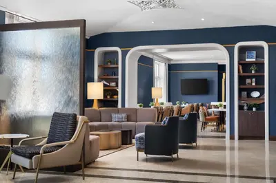 a lobby with a waiting room with couches and chairs at The Well House Hamilton, Tapestry Collection By Hilton in Hamilton