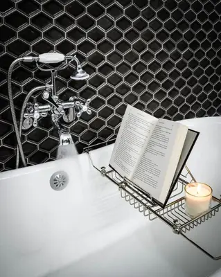 a bathtub with a book and a candle and a candle holder at Lux Townhome - Washington Park - Walk to ALL in Cincinnati