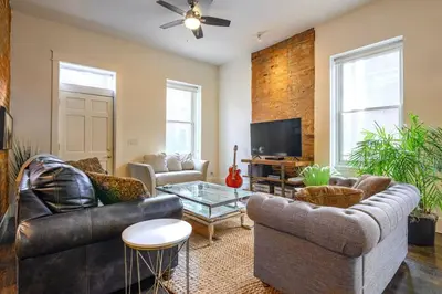 a living room with leather furniture and a tv at Lux Townhome - Washington Park - Walk to ALL in Cincinnati