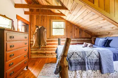 a bedroom with a bed in a log cabin at 1800s Romantic Cabin! Fireplace and 3 Jacuzzi Tubs in Paris