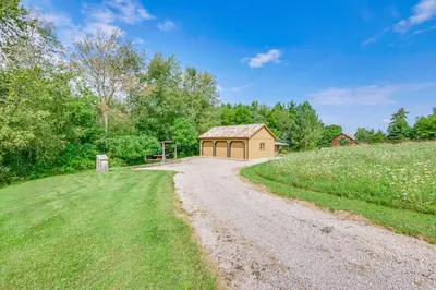 a dirt road leading to a building on a hill at 1800s Romantic Cabin! Fireplace and 3 Jacuzzi Tubs in Paris