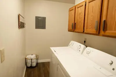 a bathroom with a white sink and wooden cabinets at The General's Quarters in Defiance