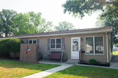 a small house with a red bench in a yard at The General's Quarters in Defiance