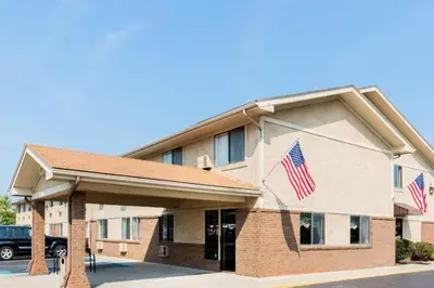 a hotel with two american flags in front of it at Super 8 By Wyndham Franklin/Middletown Area in Middletown