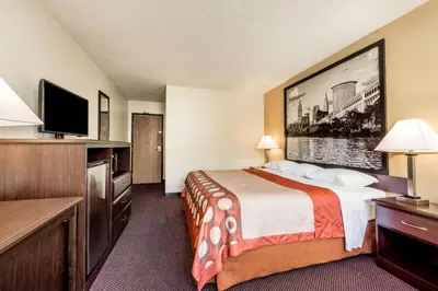 a hotel room with a bed and a flat screen tv at Super 8 By Wyndham Franklin/Middletown Area in Middletown