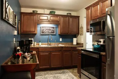 a kitchen with wooden cabinets and a sink and a refrigerator at The Aviators Lounge in Defiance