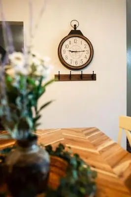 a clock hanging on a wall next to a table at The Aviators Lounge in Defiance