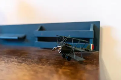 a toy plane sitting on a table next to a bed at The Aviators Lounge in Defiance