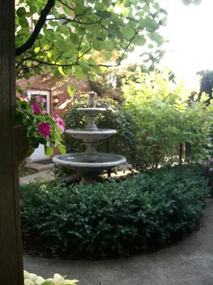 a fountain in the middle of a garden with flowers at The Mount Vernon Inn in Mount Vernon