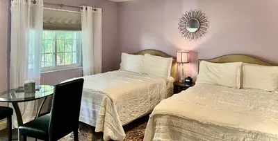 a bedroom with two beds and a table and a mirror at The Mount Vernon Inn in Mount Vernon