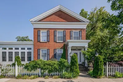 a red brick house with a white fence at The Mount Vernon Inn in Mount Vernon