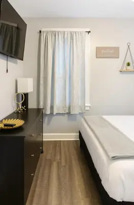 a bedroom with a bed and a dresser and a window at Spacious Three Bedroom Parma Home Sleeps six Near Cleveland in Parma