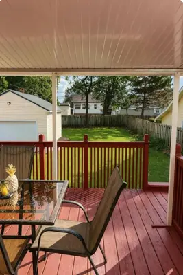 a patio with a table and chairs on a deck at Spacious Three Bedroom Parma Home Sleeps six Near Cleveland in Parma