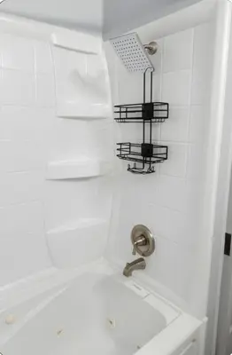 a white bathroom with a shower with a sink at Spacious Three Bedroom Parma Home Sleeps six Near Cleveland in Parma