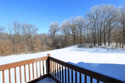 a balcony with a snow covered field and trees at The Den at Buckskin- Entire House in Frankfort, OH in Greenfield