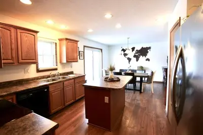 a kitchen with a refrigerator and a dining room at The Den at Buckskin- Entire House in Frankfort, OH in Greenfield