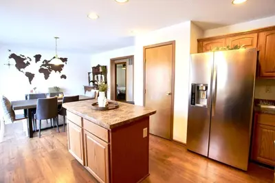 a kitchen with a stainless steel refrigerator and a table at The Den at Buckskin- Entire House in Frankfort, OH in Greenfield