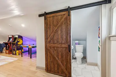 a sliding barn door in a room with a toilet at Meerkat Manor- 5 Min Drive to CLE Clinic in Cleveland
