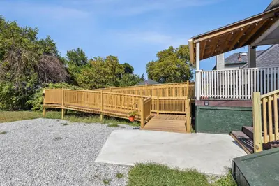 a wooden deck with a wooden railing on a house at Meerkat Manor- 5 Min Drive to CLE Clinic in Cleveland