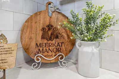 a wooden sign for a merchant manor with a vase of flowers at Meerkat Manor- 5 Min Drive to CLE Clinic in Cleveland