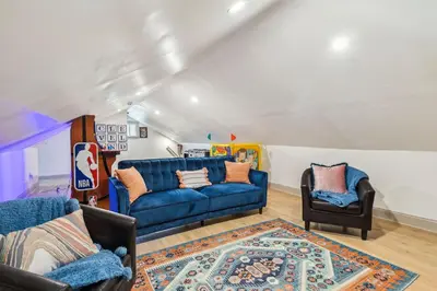 a living room with a blue couch and two chairs at Meerkat Manor- 5 Min Drive to CLE Clinic in Cleveland