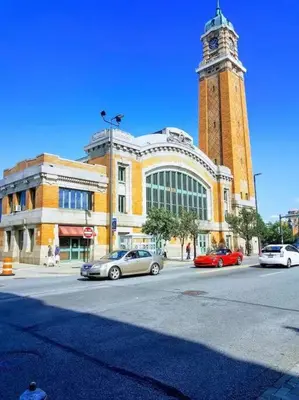 a building with a clock tower with cars parked in front of it at Cozy Bungalow 10 Min to DTWN CLE in Euclid