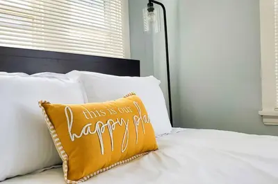 a bed with a pillow that says this is our laundry room at Cozy Bungalow 10 Min to DTWN CLE in Euclid