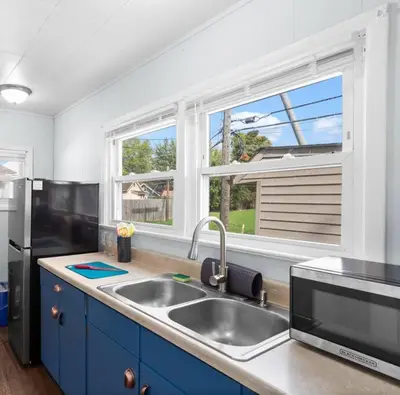a kitchen with a sink and a large window at Cozy Bungalow 10 Min to DTWN CLE in Euclid
