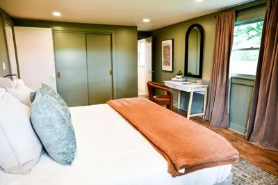 a bedroom with a bed and a desk and a table at The Bidwell Bungalow in Amanda