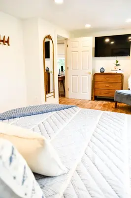 a bedroom with a bed and a mirror at The Bidwell Bungalow in Amanda