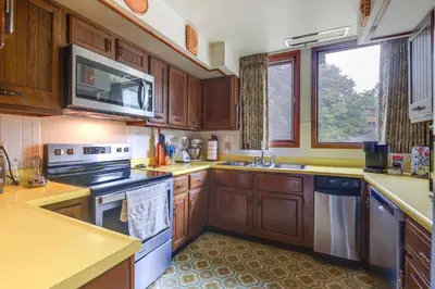 a kitchen with wooden cabinets and a stove top oven at Retro Ohio Home on 1-Acre Property in Xenia