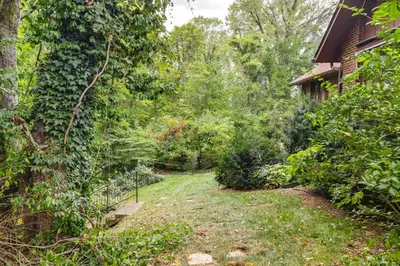 a yard next to a house with a fence at Retro Ohio Home on 1-Acre Property in Xenia