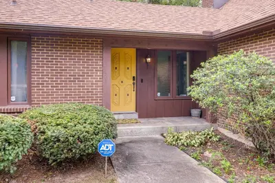 a house with a yellow door and a sign in front at Retro Ohio Home on 1-Acre Property in Xenia