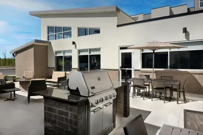 an outdoor patio with a grill and tables and chairs at Residence Inn by Marriott Dayton Miamisburg in Miamisburg
