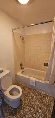 a bathroom with a toilet and a bath tub at Beverly Hills Inn in Aberdeen