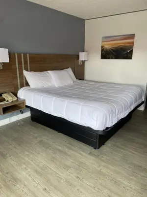 a bedroom with a large bed with white sheets at Beverly Hills Inn in Aberdeen