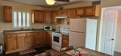a kitchen with wooden cabinets and a white refrigerator at Beverly Hills Inn in Aberdeen