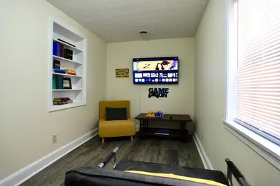 a living room with a couch and a chair and a tv at The Lounge - Downtown Chillicothe in Chillicothe