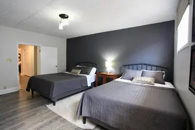 a bedroom with two beds and a night stand with a lamp at The Lounge - Downtown Chillicothe in Chillicothe