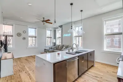 an open kitchen and living room with white walls and wood floors at Top Rated - Free Parking - 1-br Condo OTR in Cincinnati