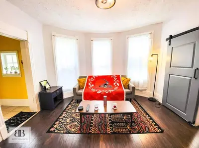 a living room with a red chair and a table at Stylish King Bed, 2BDRM, 1 Mile to DTWN, Game Room in Cleveland