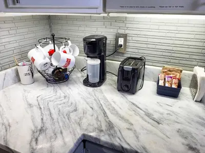 a counter top with coffee cups and appliances on it at Stylish King Bed, 2BDRM, 1 Mile to DTWN, Game Room in Cleveland