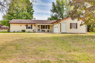 a white house with a yard at Peaceful Home Near Youngstown Fenced Backyard! in Niles