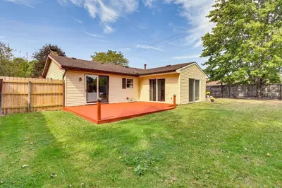 a house with a large deck in a yard at Peaceful Home Near Youngstown Fenced Backyard! in Niles