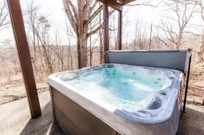 a jacuzzi tub sitting on a porch at Cozy retreat on private estate with Hot Tub in Lancaster
