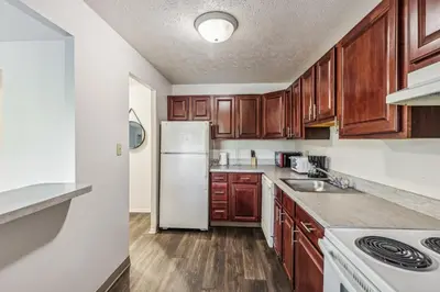 a kitchen with wooden cabinets and a white refrigerator at Scenic towers 3012 I Cozy & Comfy I Free Parking in Parma