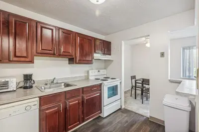 a kitchen with wooden cabinets and a sink at Scenic towers 3012 I Cozy & Comfy I Free Parking in Parma